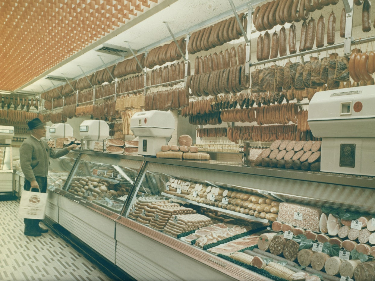 Vintage photo of a customer at the meat counter in original Schaller & Weber store